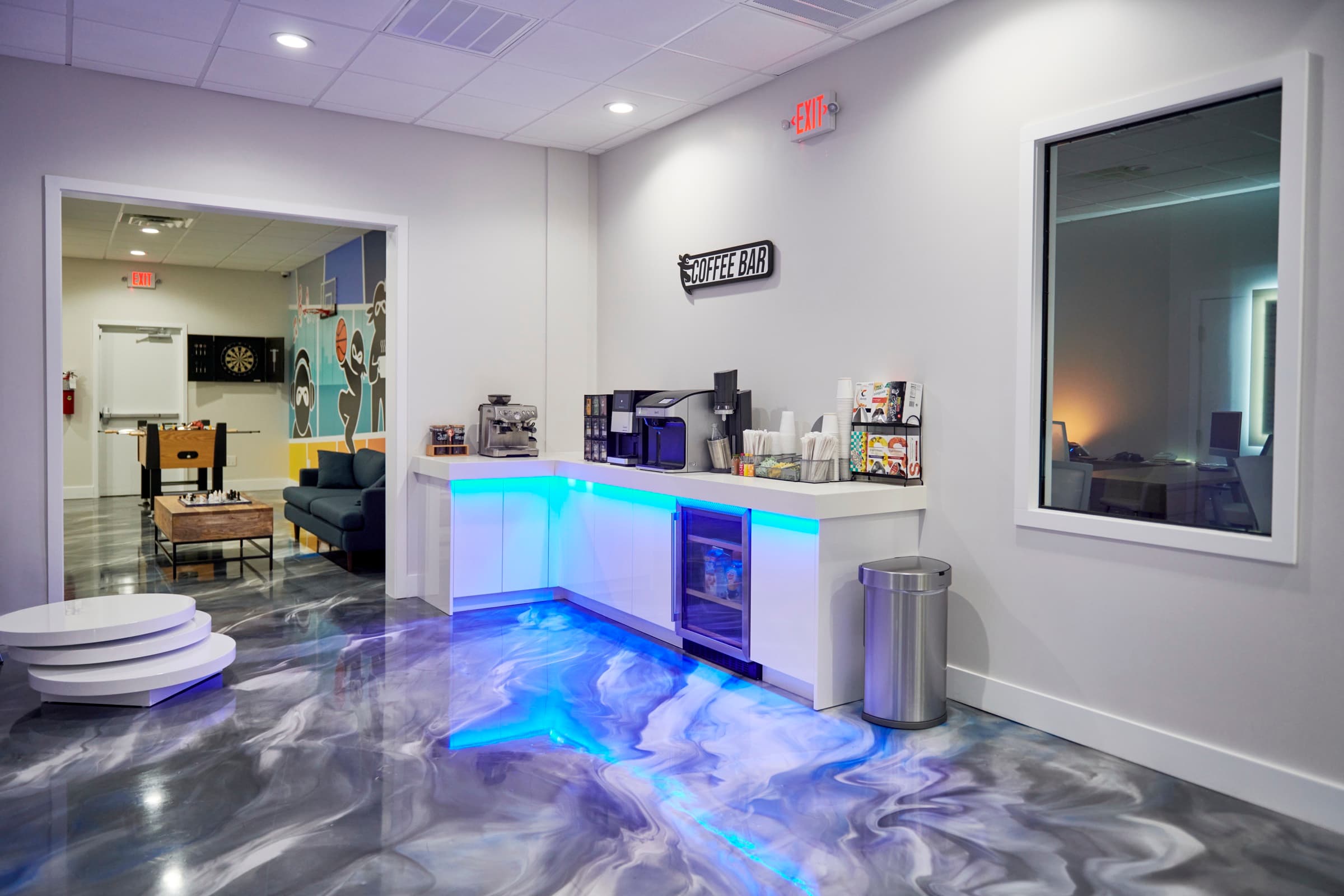 LED-lit coffee bar over a blue epoxy floor